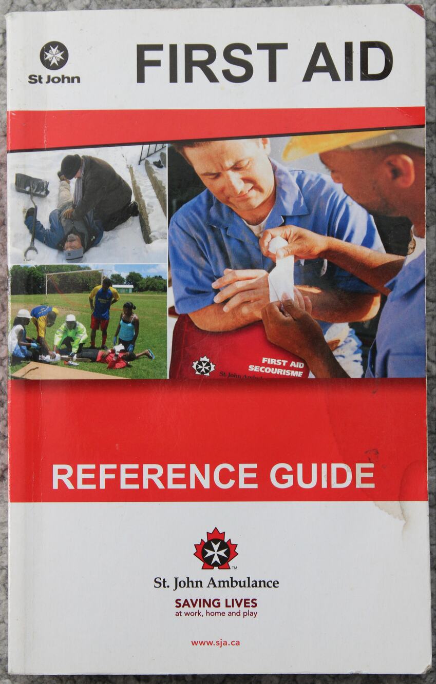 St John Ambulance First Aid reference guide paperback with red and white cover